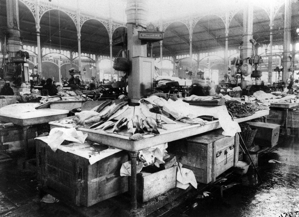 Les Halles fish market interior in Paris, late 19th century — fresh fish displayed on marble tables under the iconic iron and glass roof